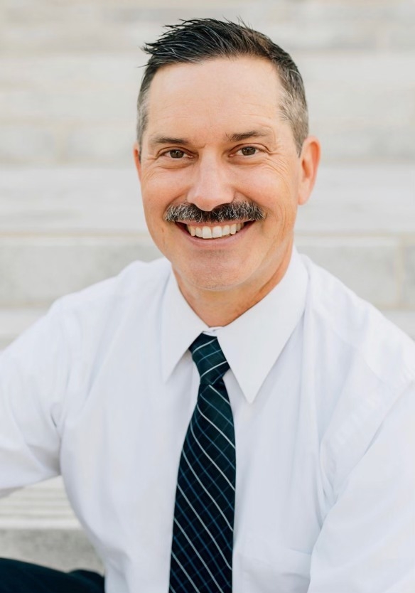 Council member Brian Plummer wearing a white shirt and black tie