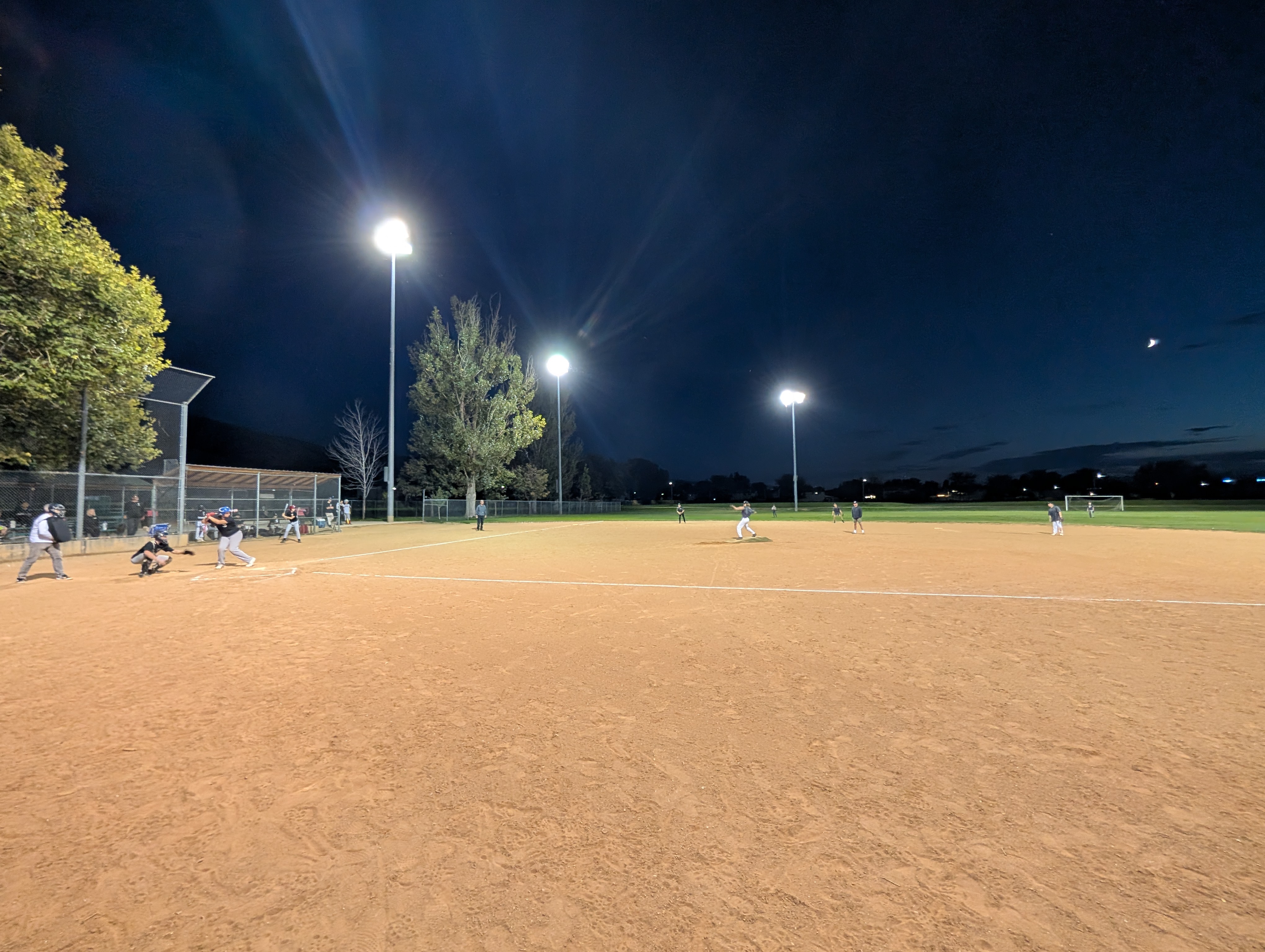 Baseball team playing a game under the lights after twilight