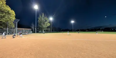 Baseball team playing a game under the lights after twilight