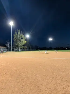 Baseball team playing a game under the lights after twilight
