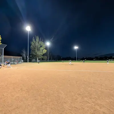 Baseball team playing a game under the lights after twilight