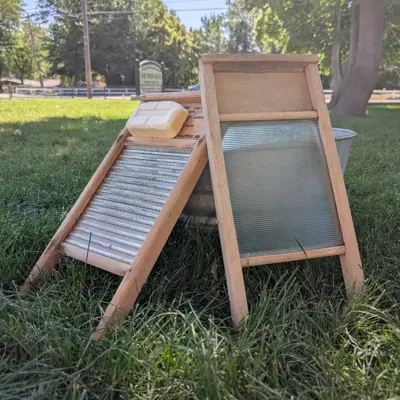Two wash boards with soap sitting against a metal tub in the whitaker yard
