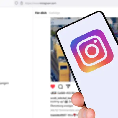 Someone holding a phone with Instagram on it with a view of a page from Instagram in the background