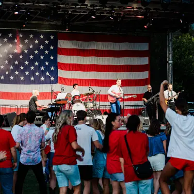 a crowd of people by a stage celebrating a concert