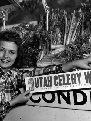 Calleen Robinson 1947 Utah Centennial Queen poses with celerey in black and white photo