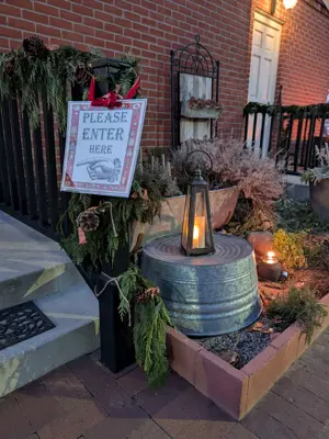 Sign with enter hear and christmas decor on exterior of whitaker house