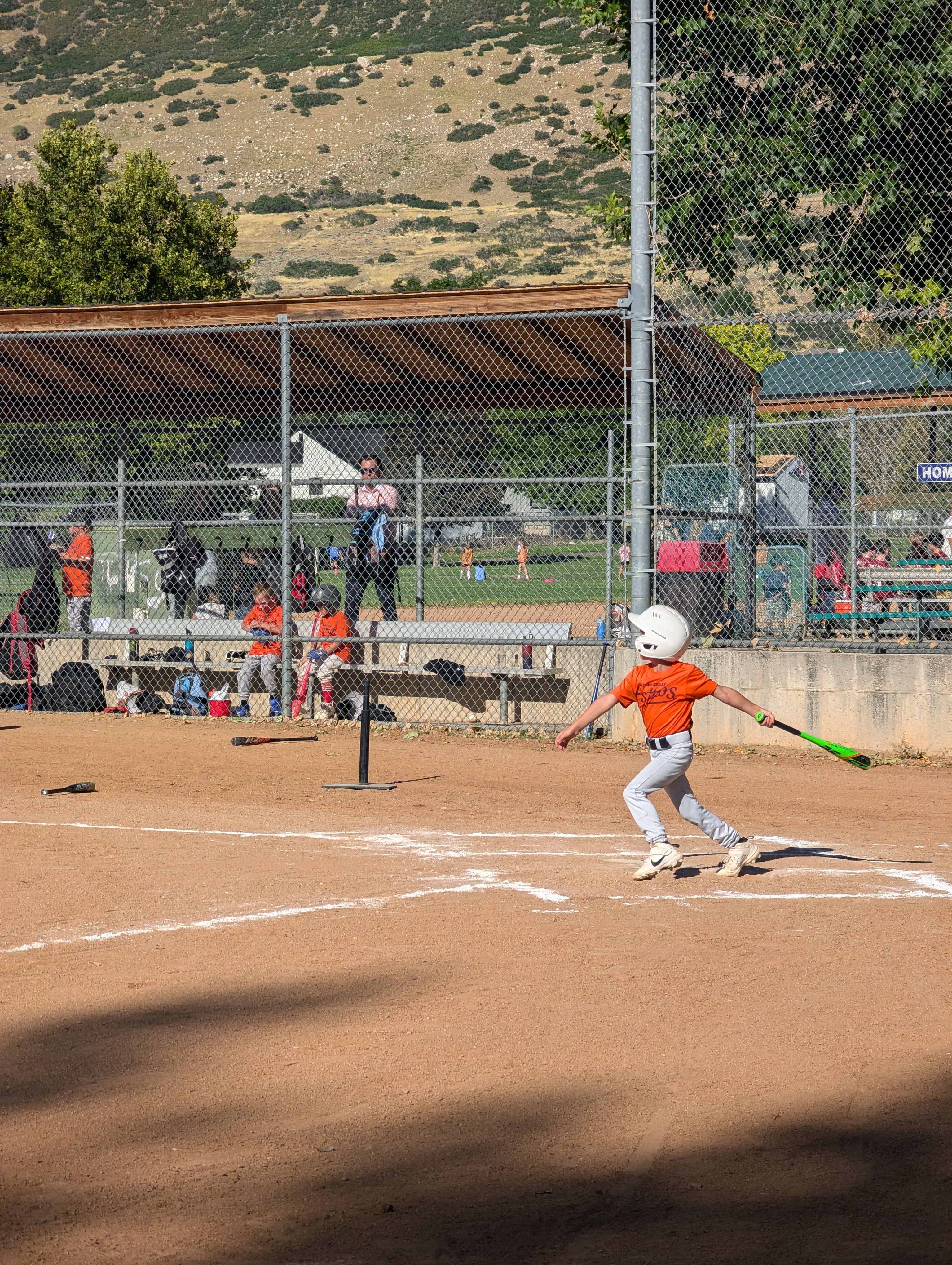 Youth baseball player having just hit the ball