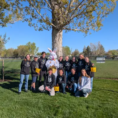 Youth council poses with the Easter Bunny on a beautful sunny morning in the park by a large tree