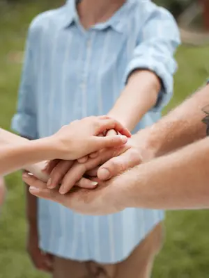 Hands coming together from mutiple people in joint effort