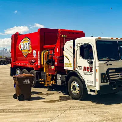 a red garbage truck with the ace disposal logo on the side