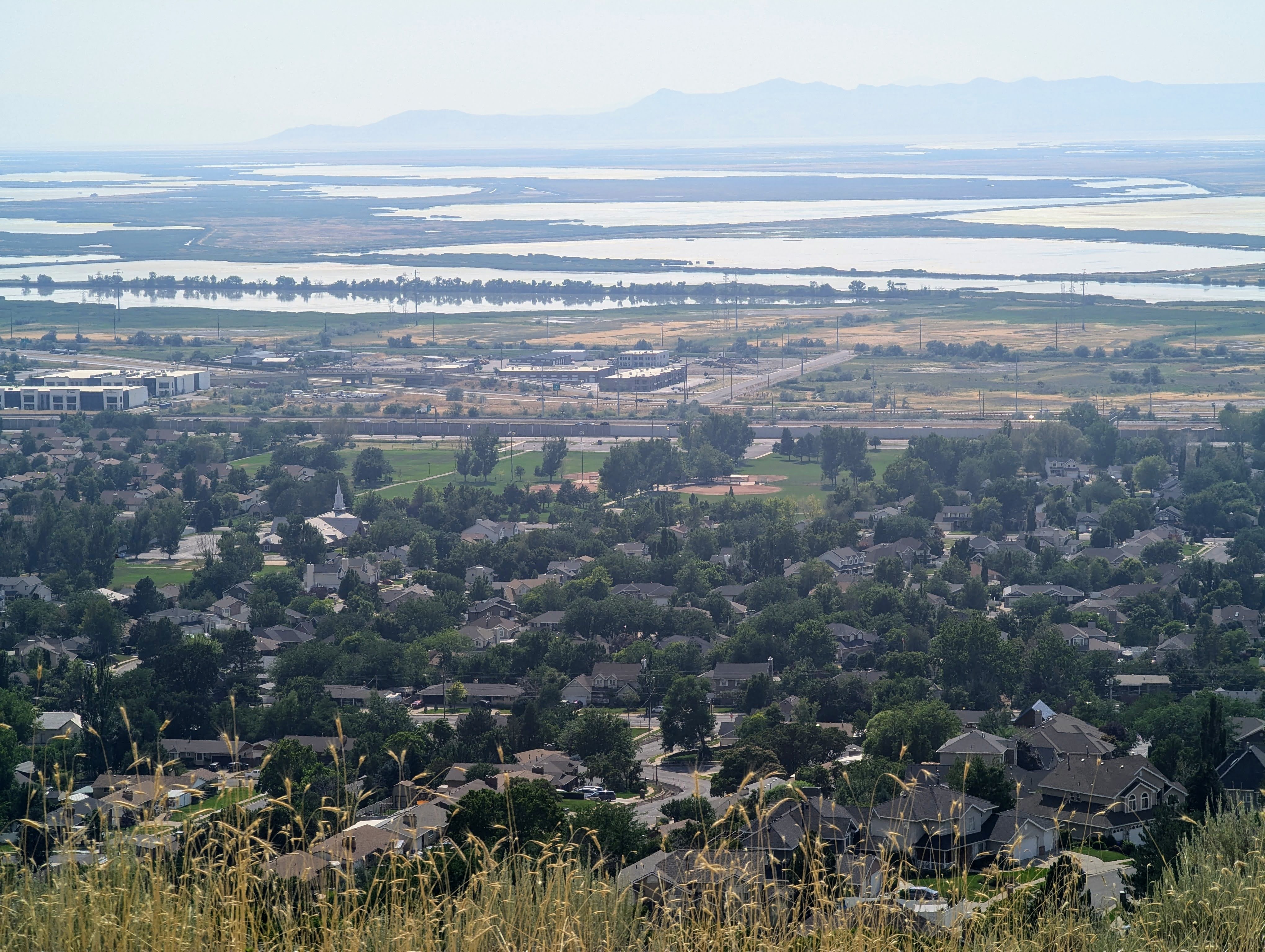 Spring day view of centerville community park baseball diamonds and great salt lake from centerville's hillside