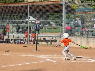 Youth baseball player having just hit the ball
