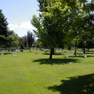 a grassy field that includes cemetery headstones.