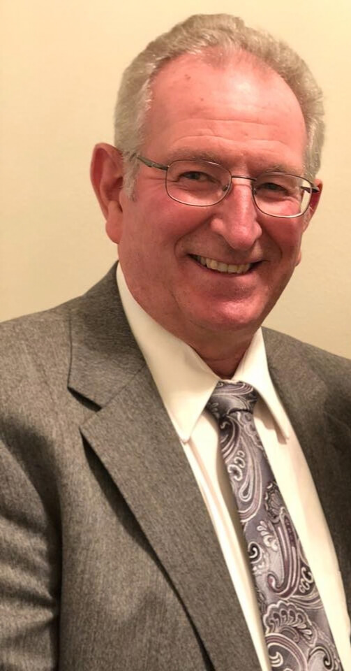 Council member Rick Bangerter wearing a gray suit with a purple tie