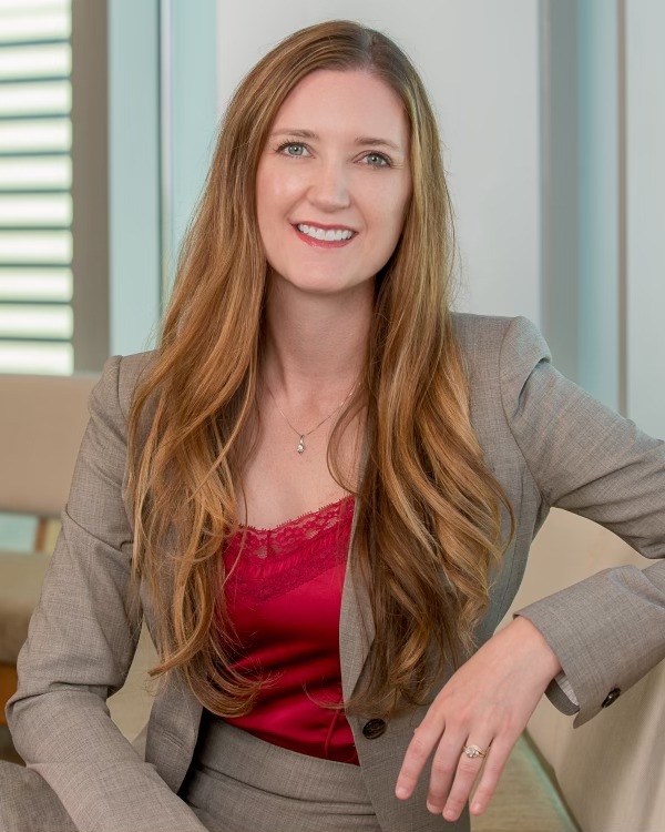 Council member cheylynn Hayman wearing a red blouse with a brown jacket