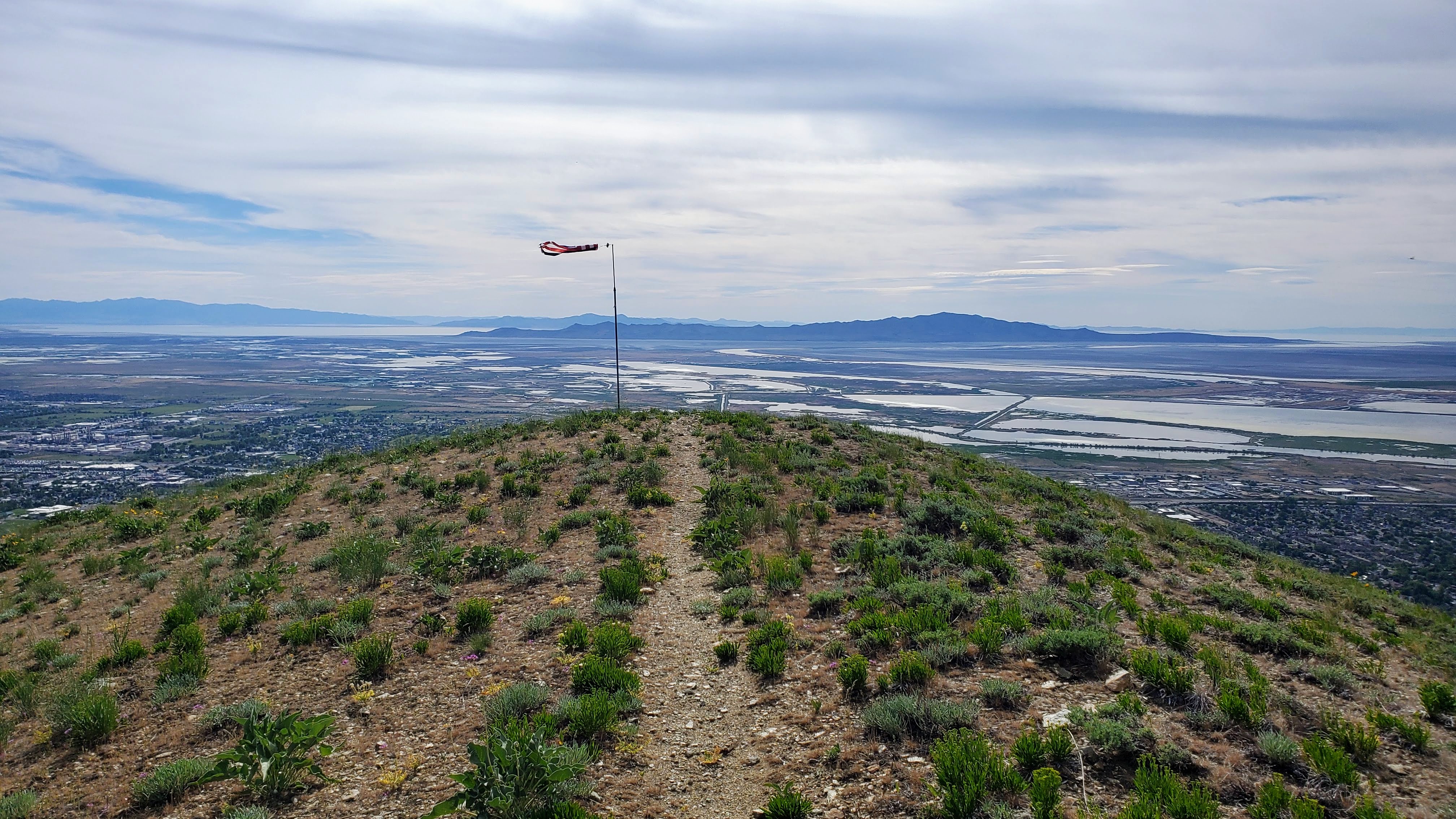 a path leading to an American flagpole on top of a mountain